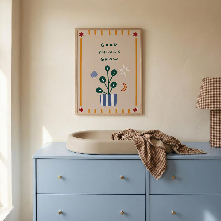 a blue dresser with a plant drawing on the wall above it, and a towel on top of the dresser.