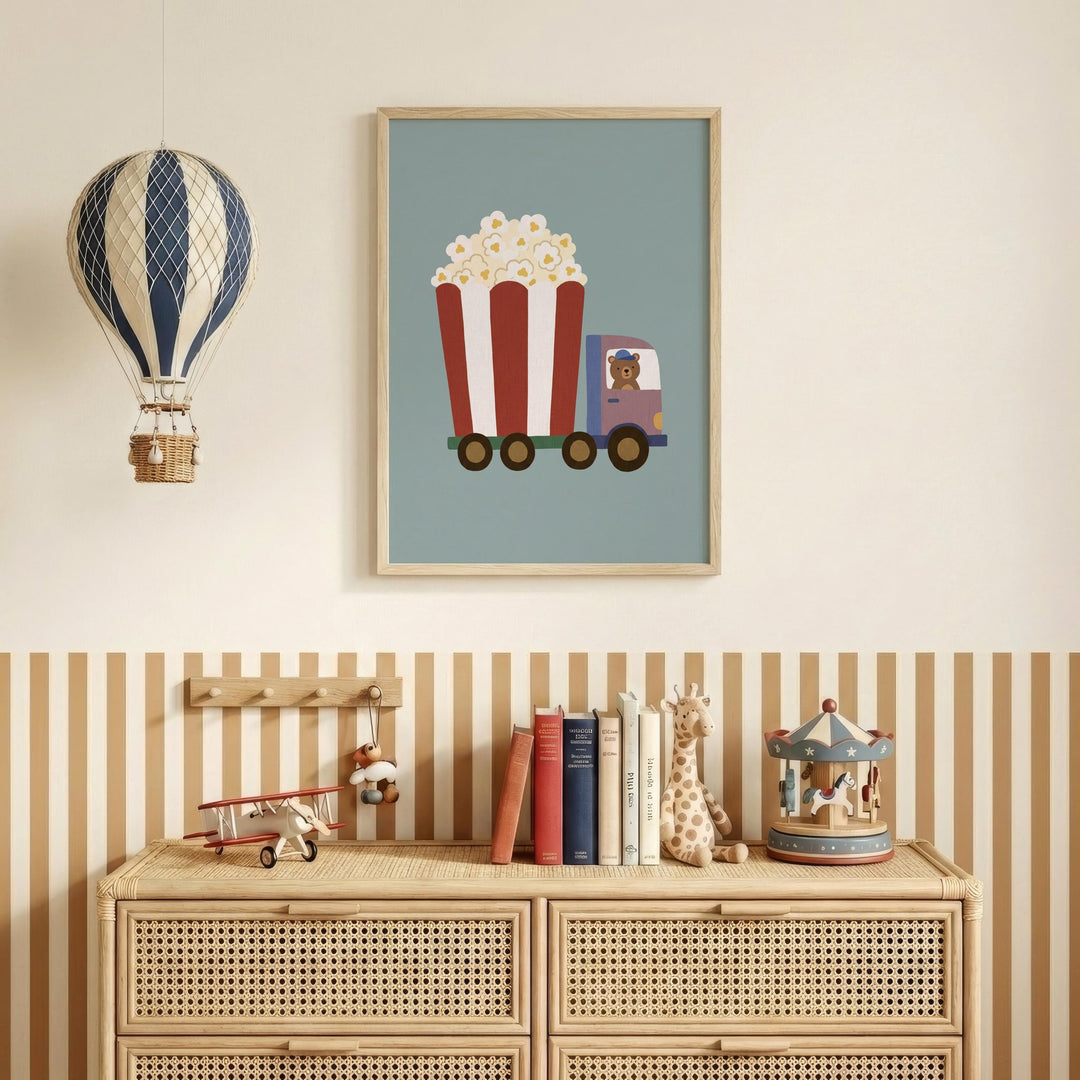 a wooden dresser with a framed picture of a hot air balloon carrying a red and white striped popcorn cart, a toy airplane, and a carousel. The dresser also has a collection of books and toys on top.
