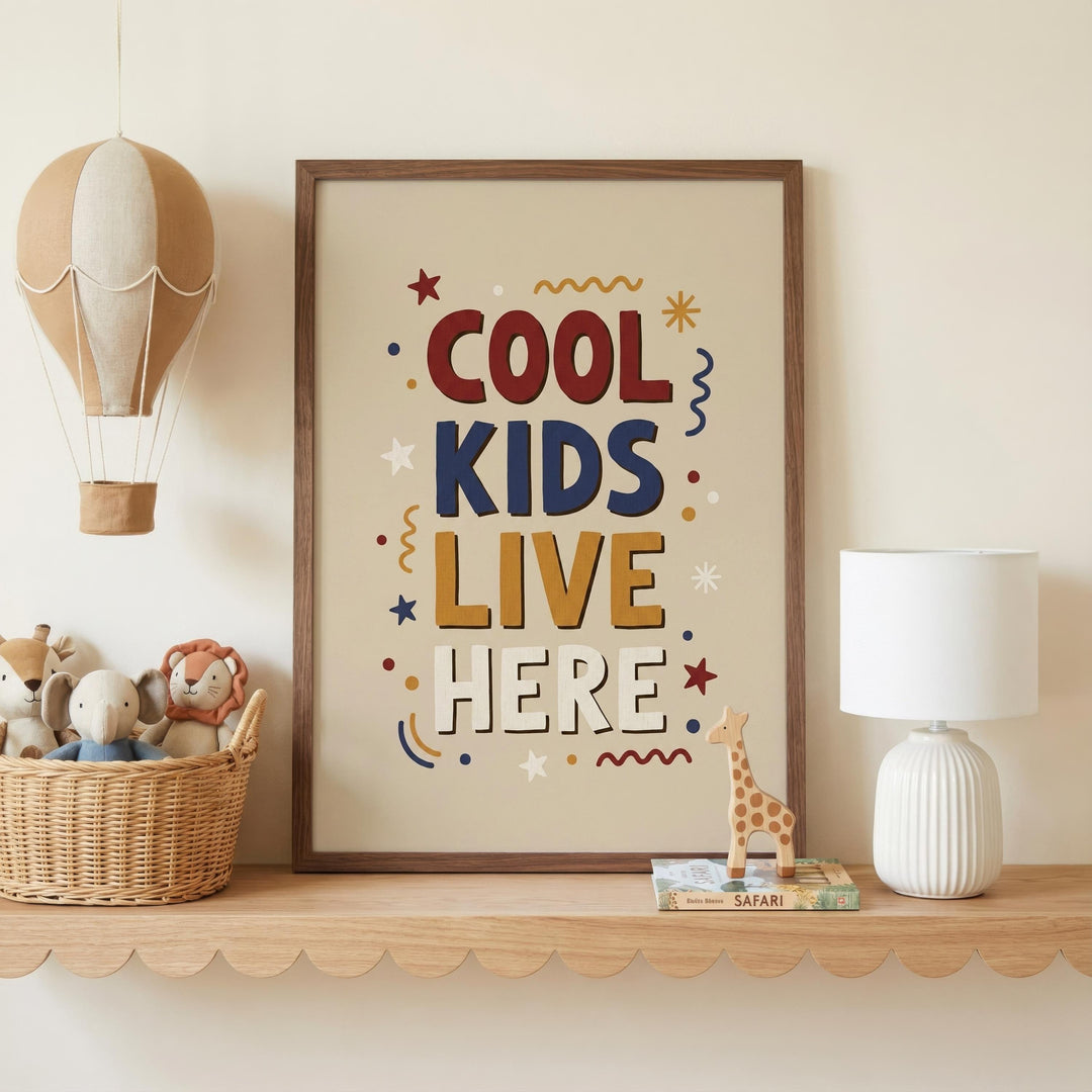a framed poster with the text "COOL KIDS LIVE HERE" on it, placed on a shelf next to a lamp and a basket of stuffed animals.