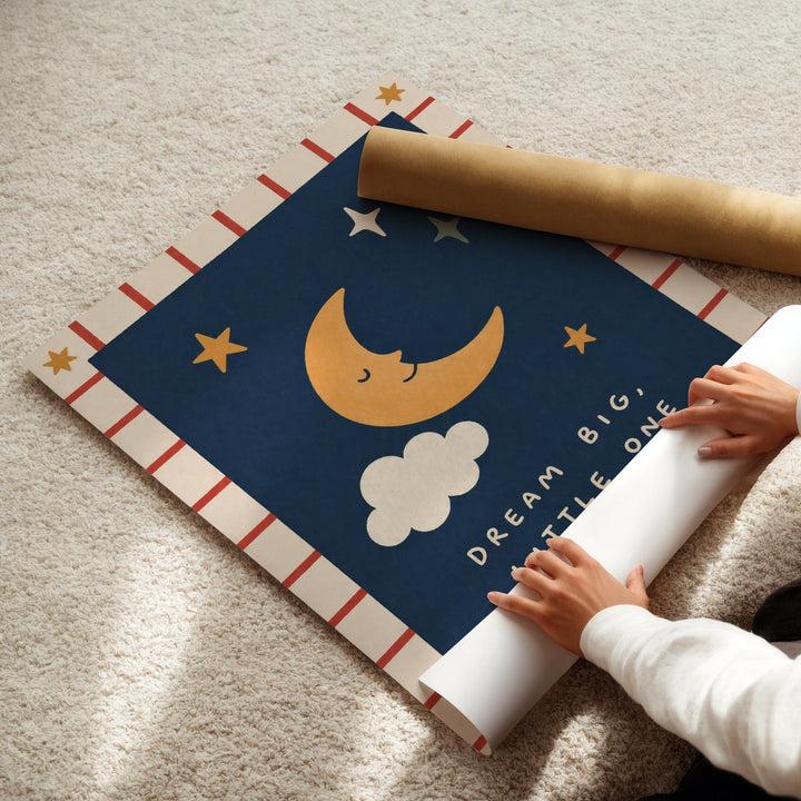 A person's hands are rolling up a blue poster with a crescent moon and stars design, which appears to be a decorative piece.