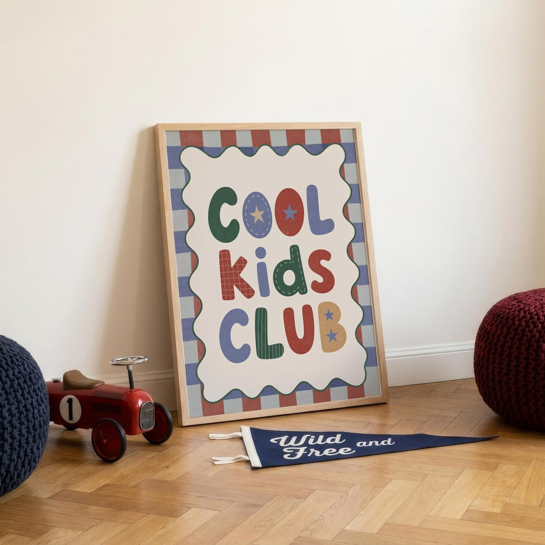 a framed sign that reads "Cool Kids Club" with a decorative border, placed on a wooden floor next to a toy tractor and a blue flag.