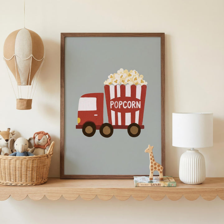a framed poster of a red and white popcorn truck, a basket of stuffed animals, and a lamp on a shelf.
