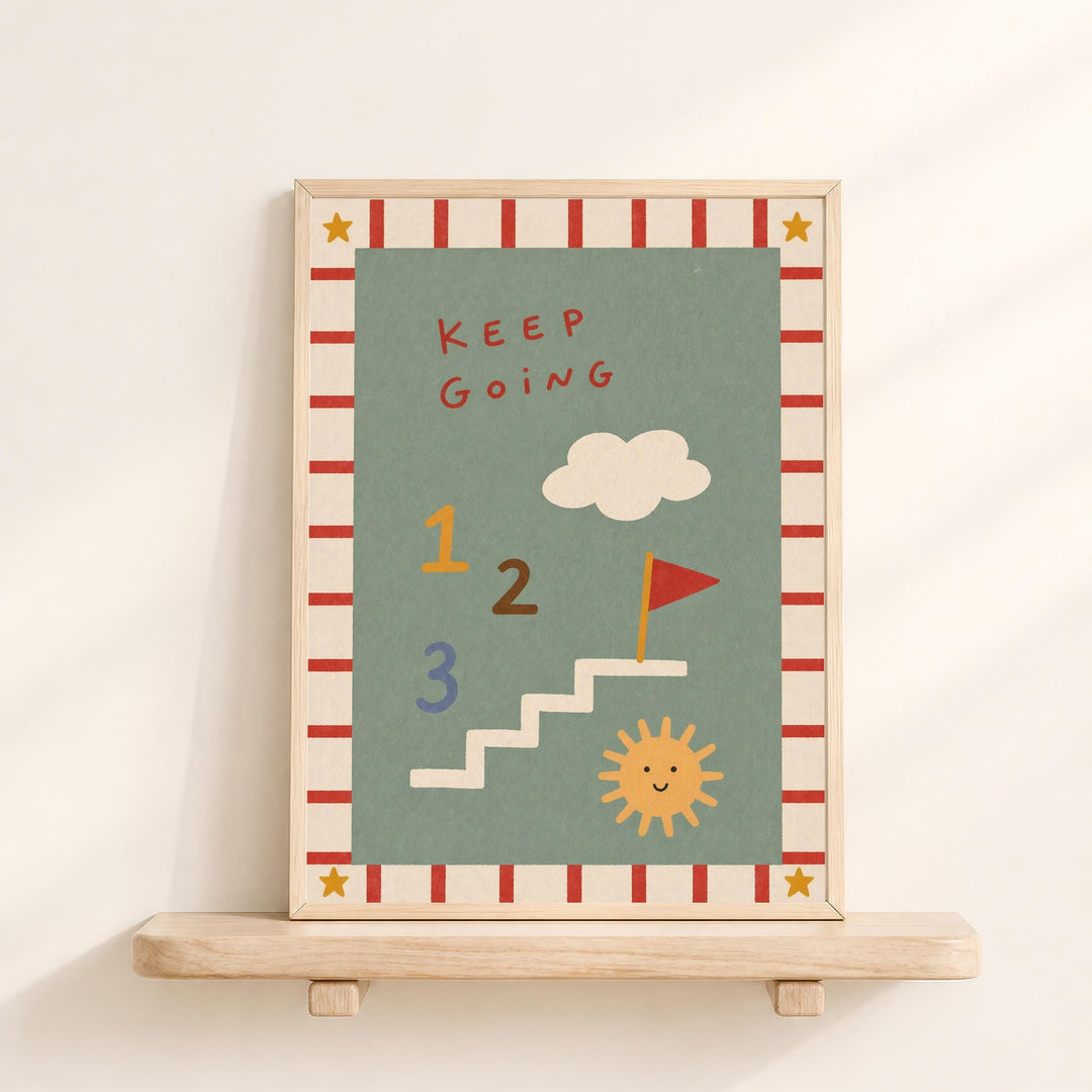 The image is a framed poster with a colorful design featuring a cloud, sun, and stairs. The poster has a motivational message that reads "Keep Going" and includes numbers 1, 2, and 3. The poster is displayed on a wooden shelf against a white wall.