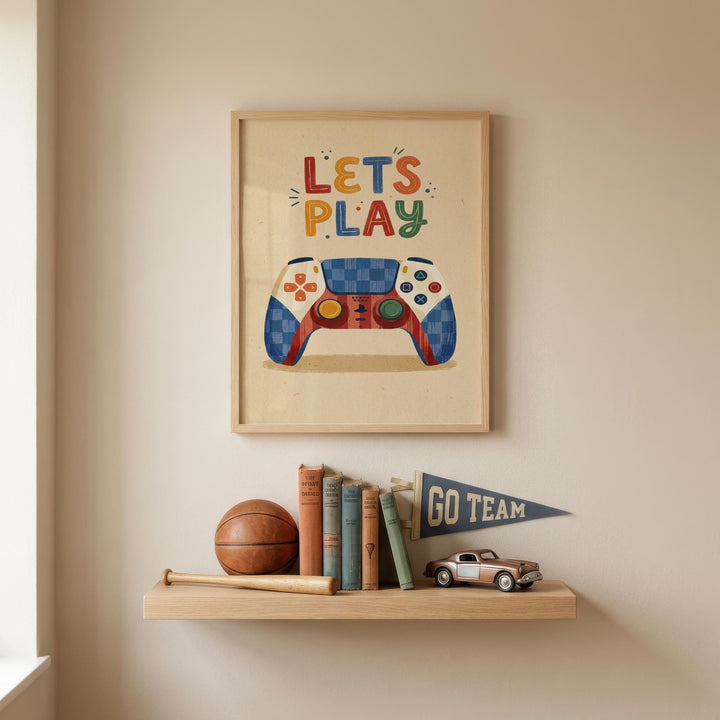 a framed poster with the text "LET'S PLAY" above a colorful illustration of a video game controller, along with a small flag that says "GO TEAM". Below the poster, there is a shelf holding various items, including a basketball, baseball bat, and a toy truck.