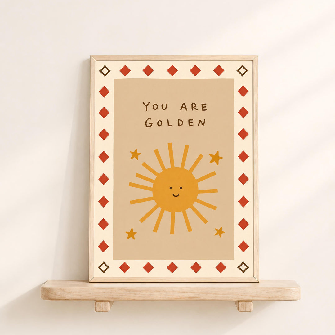 A framed poster with a cheerful sun and stars design, along with the text "You are Golden" displayed on it.