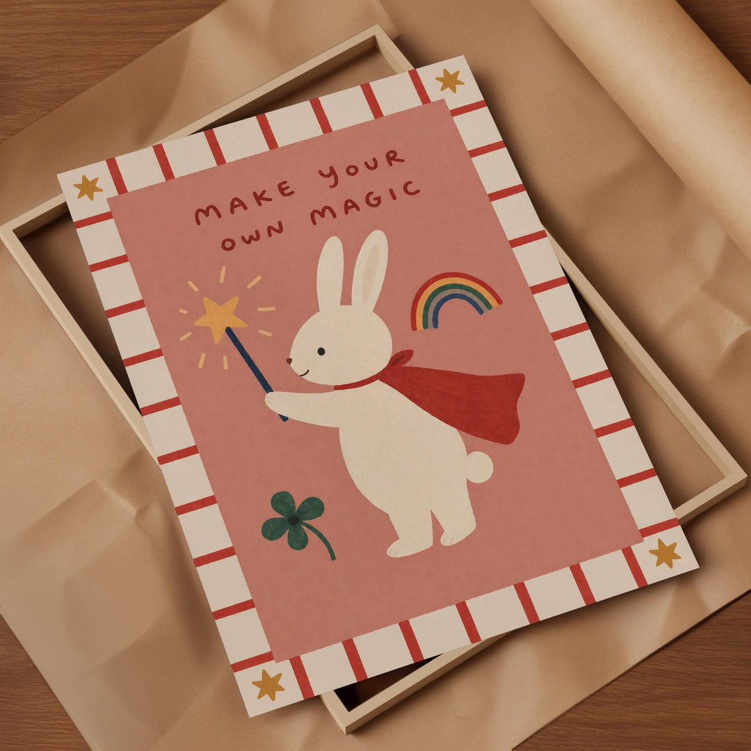 a pink card with a white rabbit holding a wand and a rainbow, along with a clover and a star. The card has a message that says "Make your own magic".