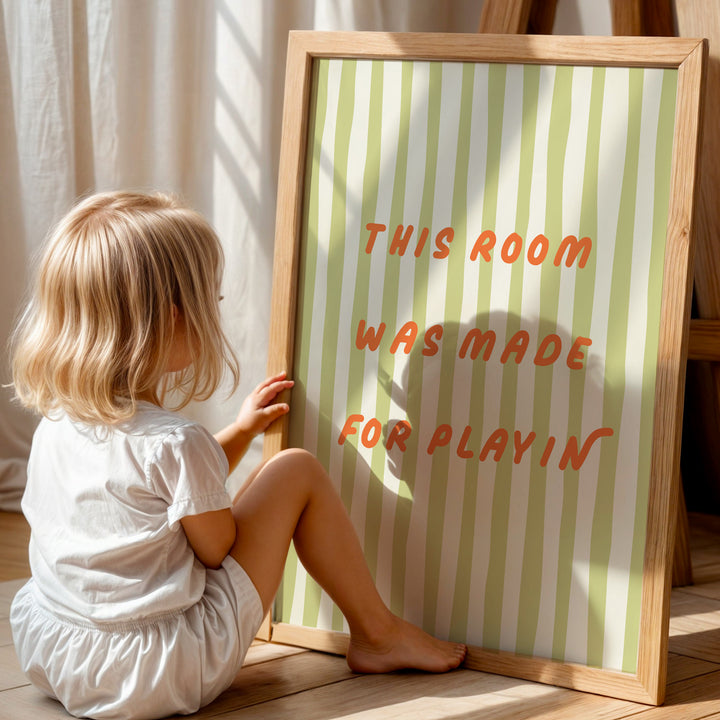 a little girl sitting on the floor next to a sign