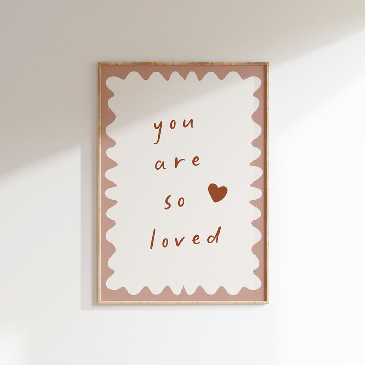 a picture hanging on a wall with the words you are so loved