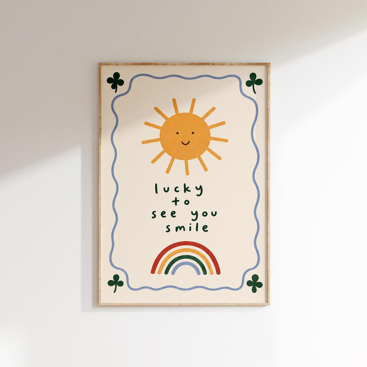 The image is a framed poster with a cheerful sun, rainbow, and shamrocks. The text on the poster reads "lucky to see you smile".
