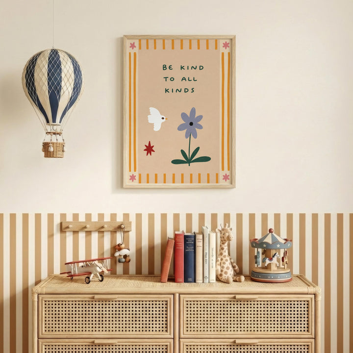 a wall with a framed poster that says "Be kind to all kinds" above a wooden dresser with a toy airplane and a carousel.