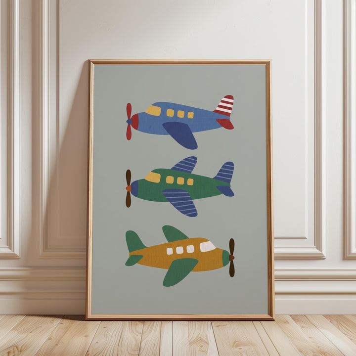 A framed print of three colorful airplanes is displayed on a wall.