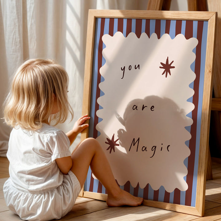 a little girl sitting on the floor next to a sign
