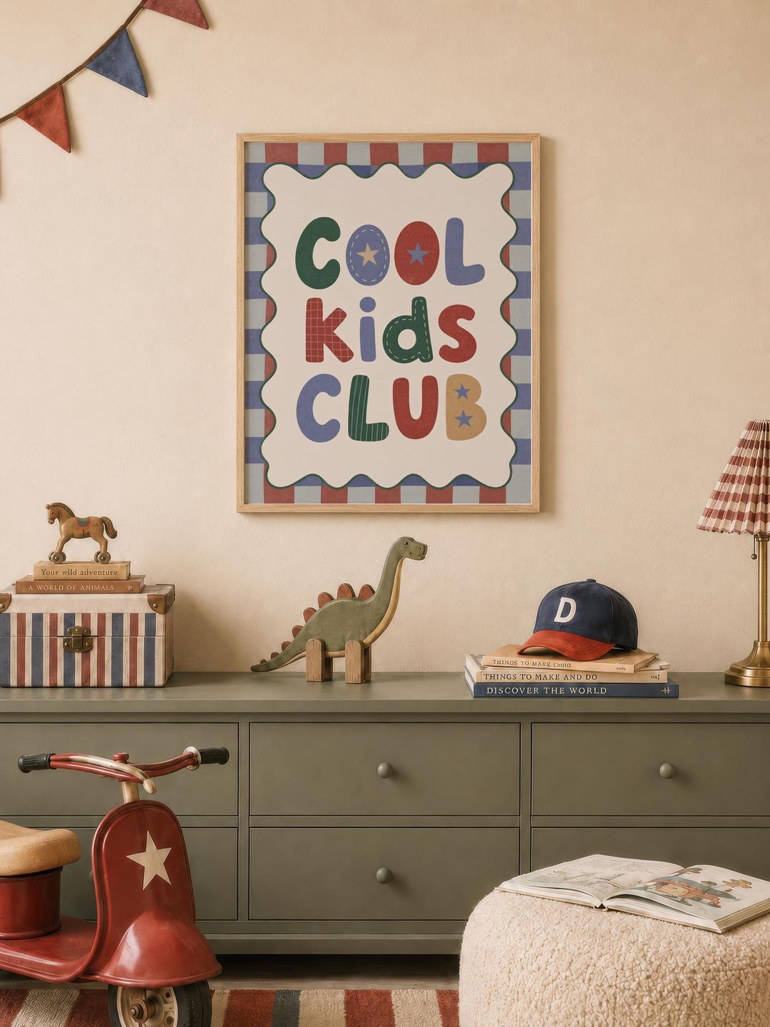 a children's room with a framed poster that says "Cool Kids Club" on the wall, a toy dinosaur, a toy horse, a stack of books, and a red toy scooter.