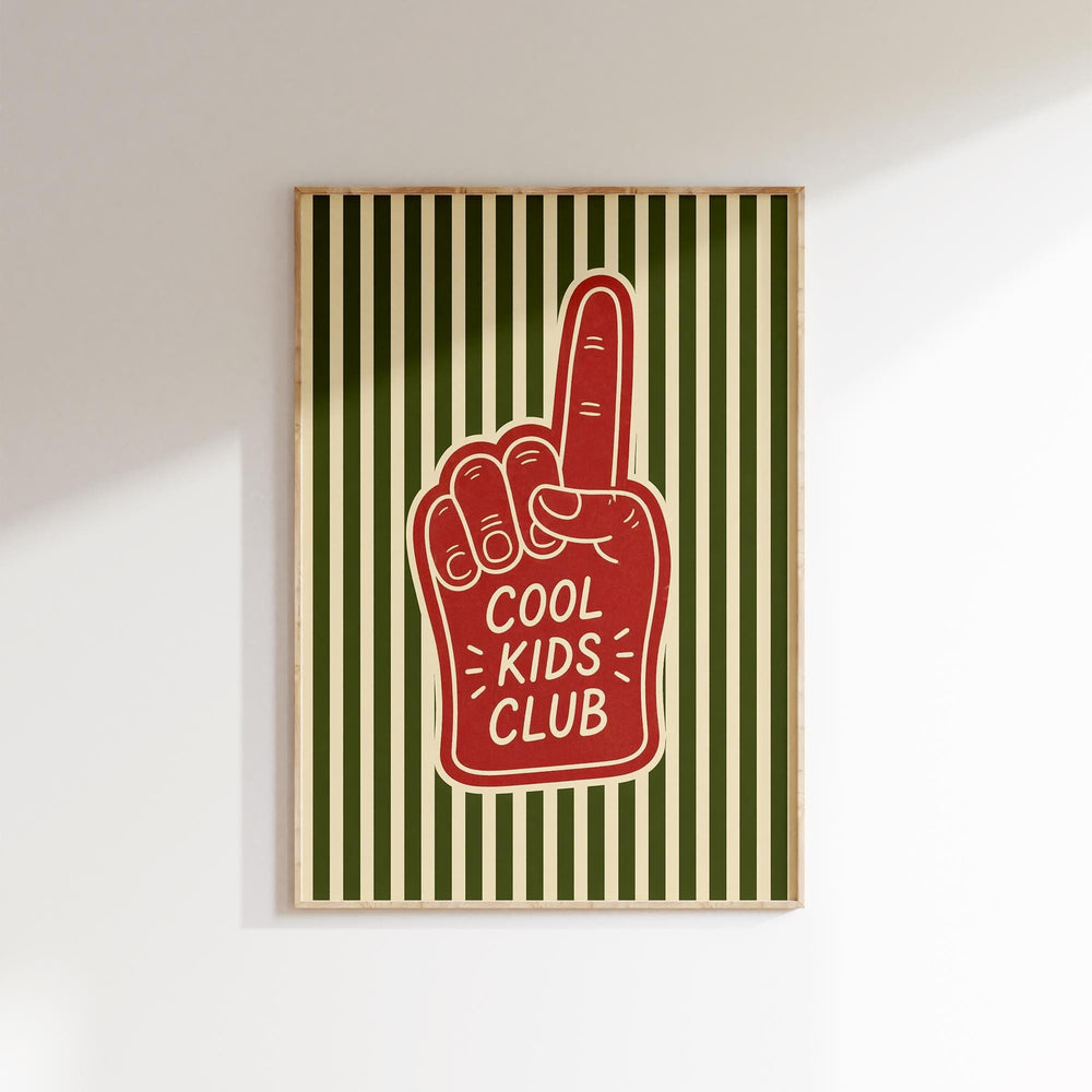 A framed poster with a red foam finger and the text "COOL KIDS CLUB" printed on it.