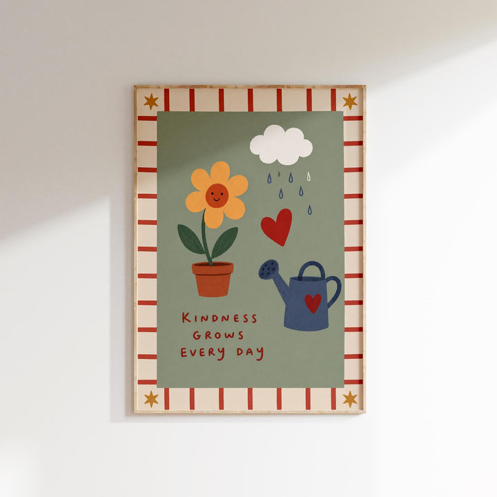 The image is a framed poster with a green background and a red and white border. It features a yellow flower, a blue watering can, and a heart symbol. The poster also includes the text "Kindness grows every day" at the bottom.