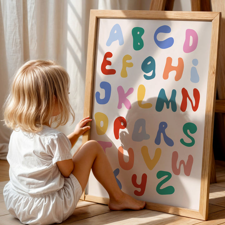 a little girl sitting on the floor next to a sign