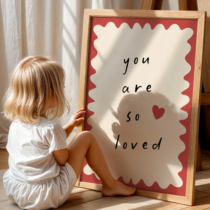 a little girl sitting on the floor next to a sign