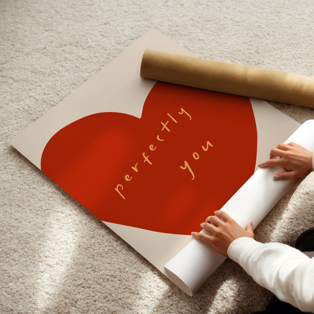 a person holding a rolled up paper with a heart on it
