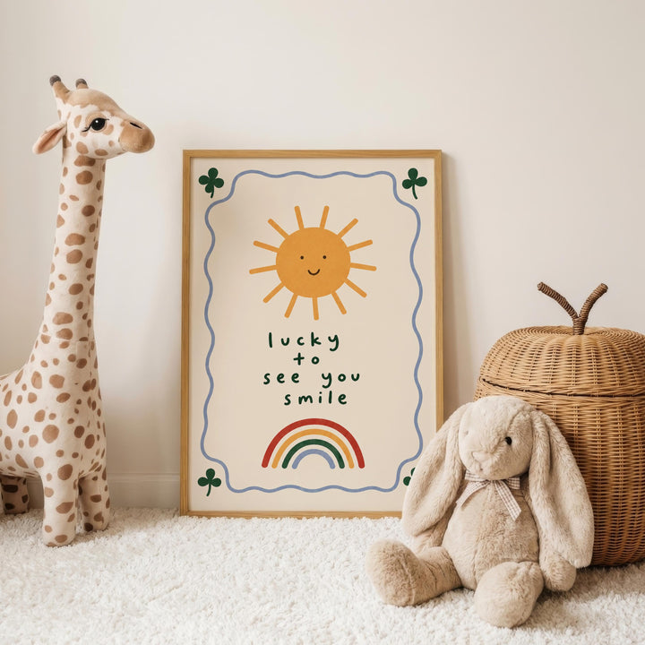 a giraffe, a stuffed rabbit, and a wicker basket, all placed on a white carpet. In the background, there is a framed poster with a sun and a rainbow, along with the text "lucky to see you smile".