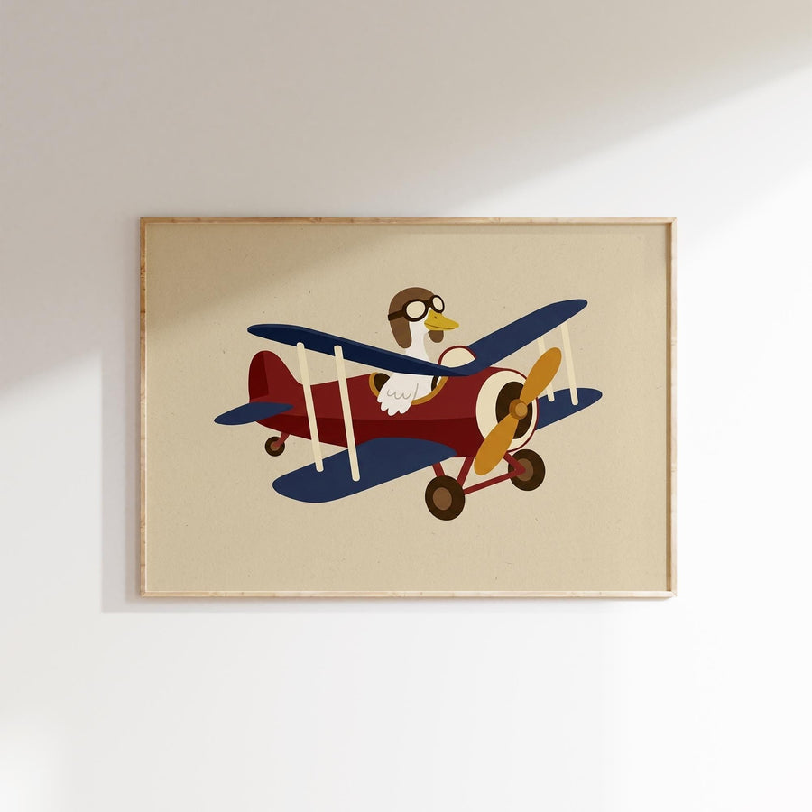 A framed illustration of a cartoon airplane with a bird piloting it.