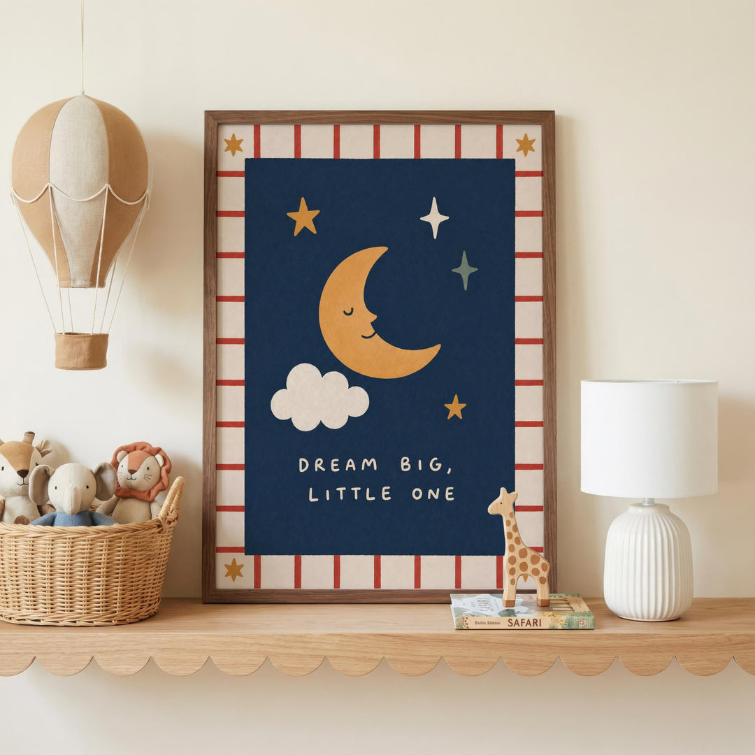 a framed poster with a crescent moon and stars, a giraffe, and the text "DREAM BIG, LITTLE ONE" on a shelf. There is also a hot air balloon, a lamp, and a basket of stuffed animals in the scene.