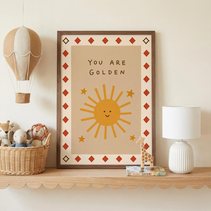 a framed poster with a sun and stars design, a hot air balloon, a basket of stuffed animals, and a lamp on a shelf.