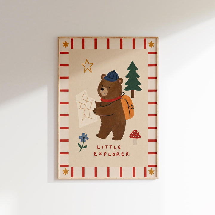 The image is a framed illustration of a bear holding a map and a backpack, with the text "Little Explorer" below the bear.