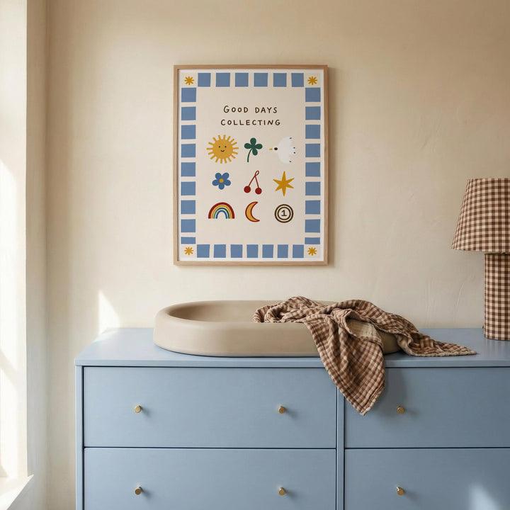 a blue dresser with a white sink on top, and a framed poster with illustrations hanging on the wall above it.