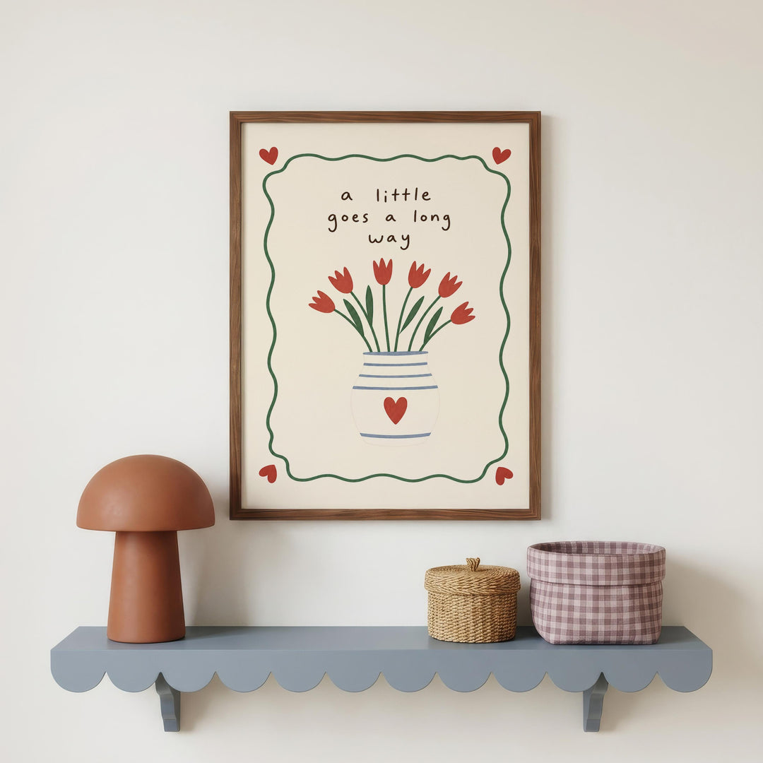 a framed picture of red tulips on a wall, accompanied by a small brown mushroom-shaped lamp and a woven basket on a gray shelf below the frame.