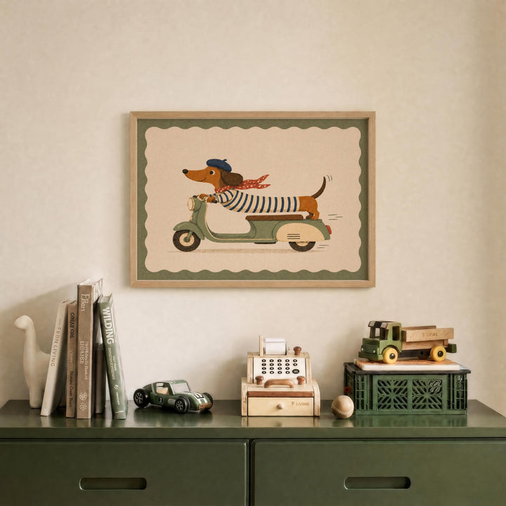 a framed illustration of a dog riding a motorcycle, displayed on a wall above a green dresser with various toys and books.