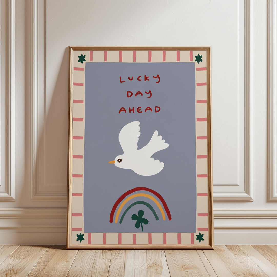 a framed poster with a white bird, a rainbow, and a clover, all set against a blue background with a border.
