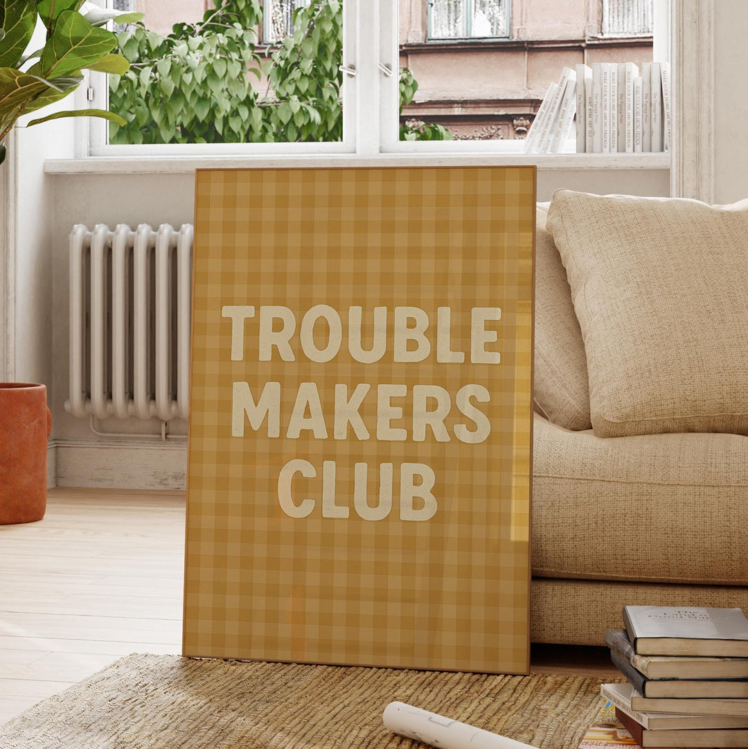 a sign that says trouble makers club next to a pile of books