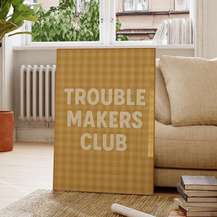 a sign that says trouble makers club next to a pile of books
