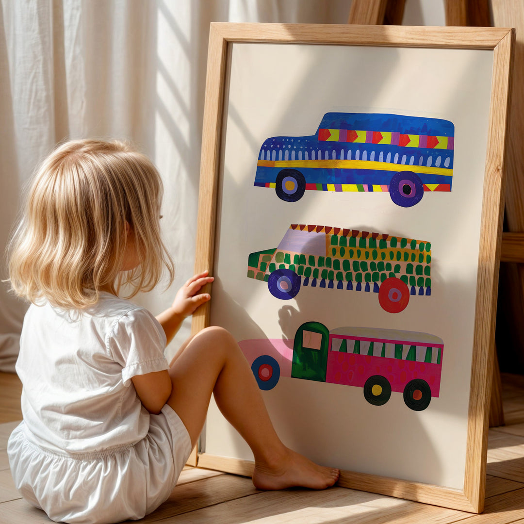 a little girl sitting on the floor next to a painting