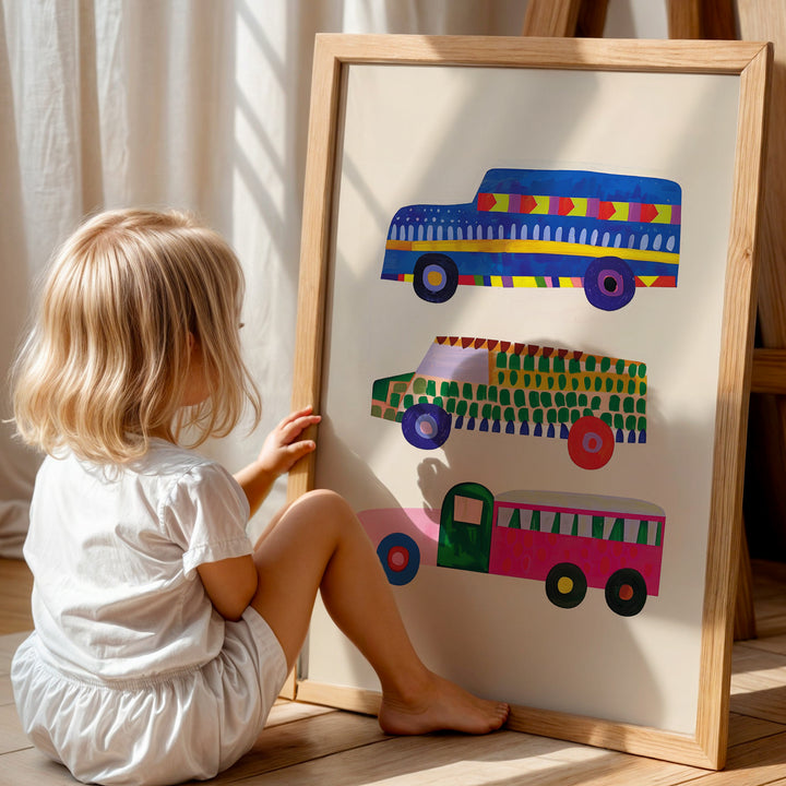 a little girl sitting on the floor next to a painting