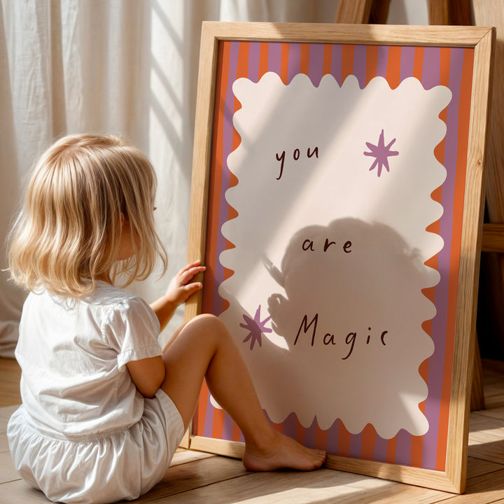 a little girl sitting on the floor next to a sign