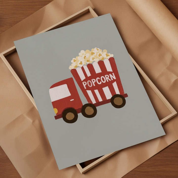 A framed illustration of a red and white striped popcorn truck with the word "POPCORN" written on it.
