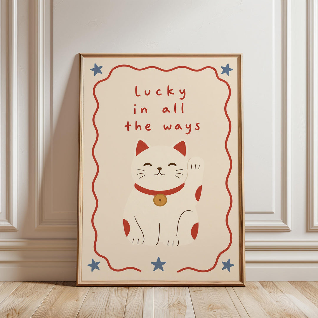 A framed poster with a white background, featuring a cartoon cat with a red collar and a wagging tail, along with the text "Lucky in all the ways" and four stars.