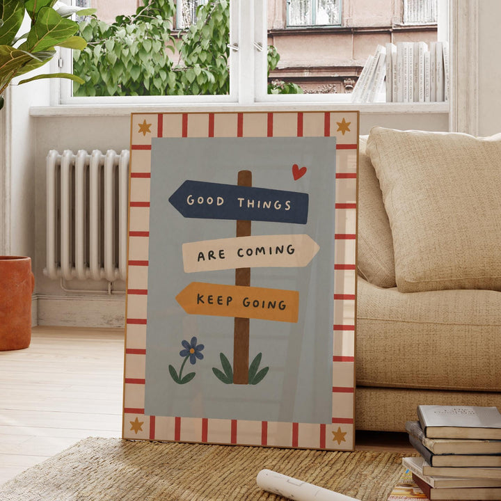 a poster with a message about good things coming and the importance of keeping going, placed on a rug in a living room setting.