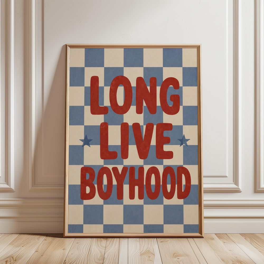 a framed poster with the text "LONG LIVE BOYHOOD" on it, placed on a wooden floor against a white wall.
