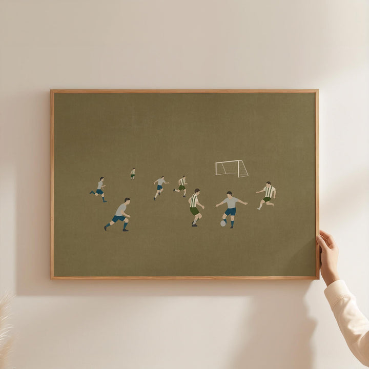 a person holding a framed picture of a soccer game