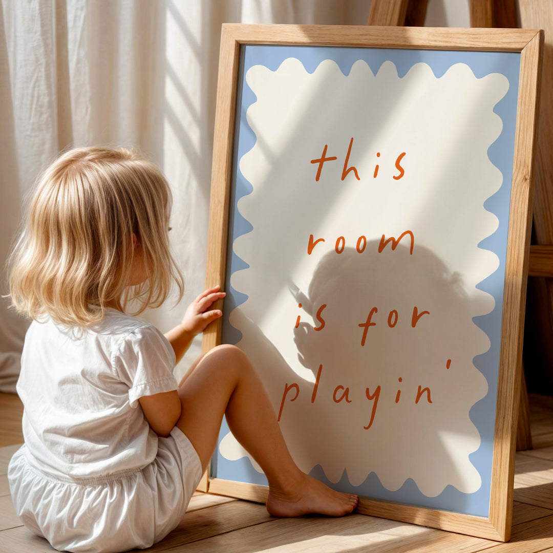 a little girl sitting in front of a sign that says this room is for playing