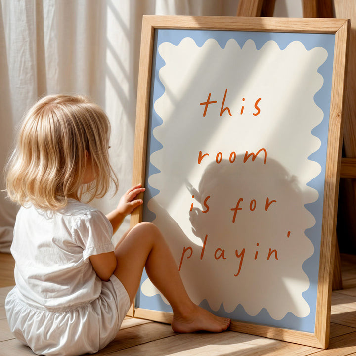 a little girl sitting in front of a sign that says this room is for playing