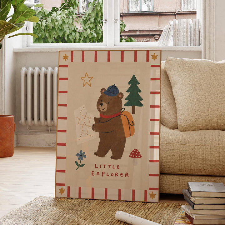 a bear holding a map and a backpack, with the text "LITTLE EXPLORER" written below the bear.