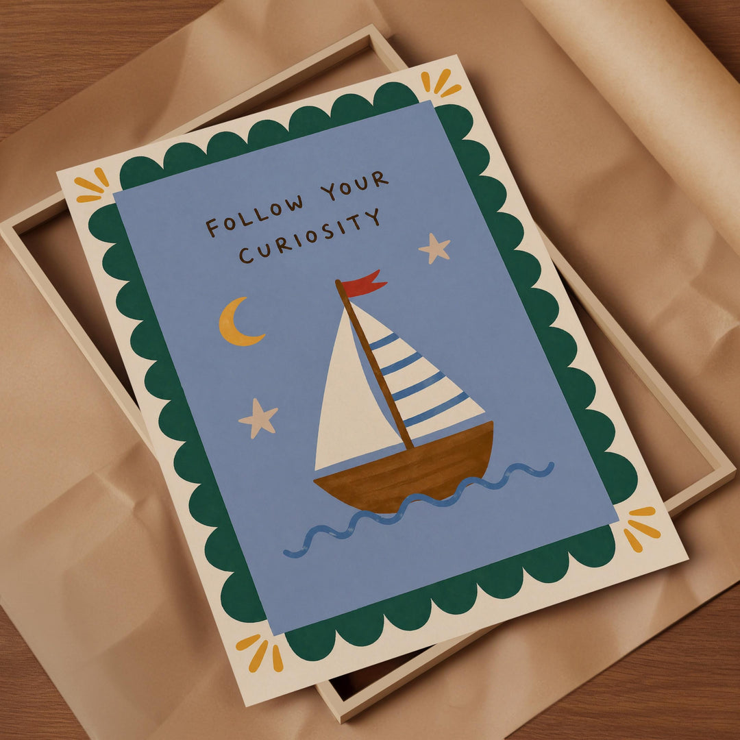 a framed card with a sailboat illustration and the text "Follow Your Curiosity" written on it.