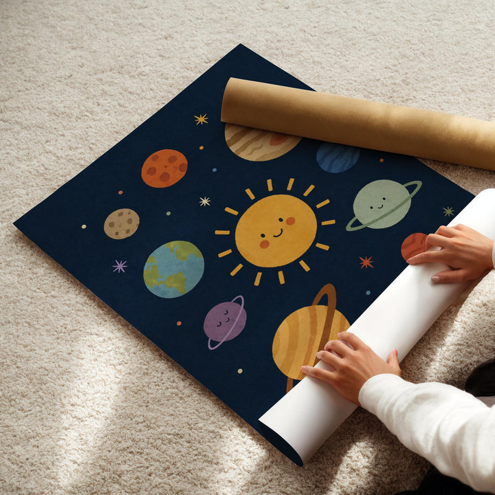 A child's hands are seen rolling up a poster depicting a colorful, cartoon-style solar system with planets and stars.