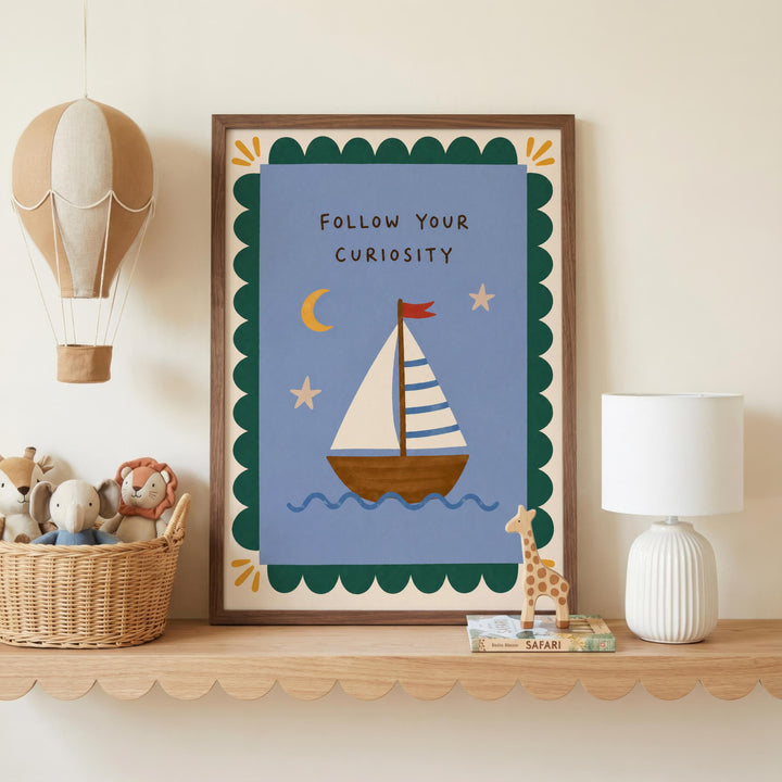 a framed picture of a sailboat on a blue background, with a motivational message "Follow Your Curiosity" written on it. The picture is displayed on a shelf, accompanied by a hot air balloon, a lamp, and a basket of stuffed animals.