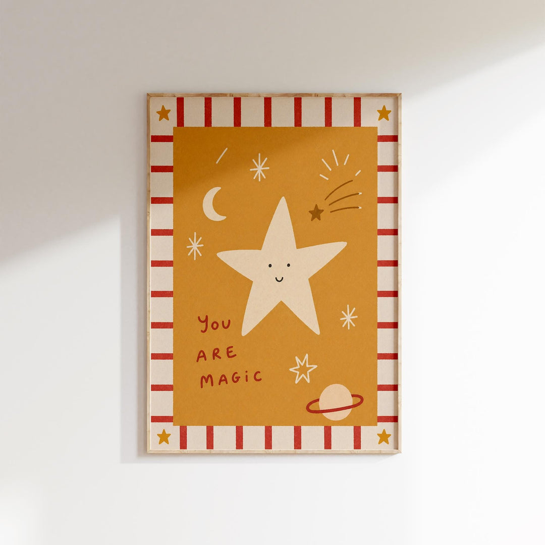 The image is a framed artwork featuring a star with a face, surrounded by celestial elements such as a crescent moon, stars, and a planet. The text "You are magical" is written below the star.