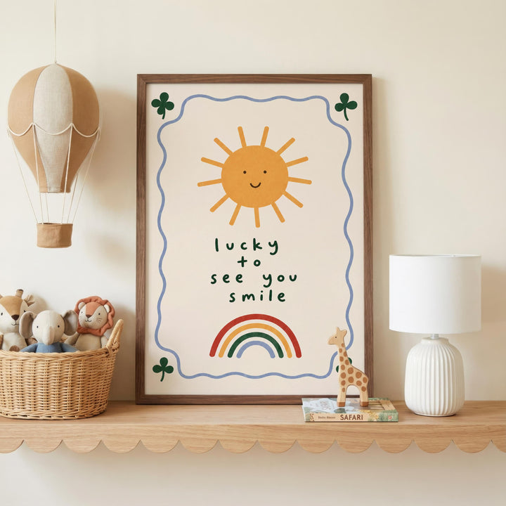 a framed poster with a sun and a rainbow, along with a message that says "lucky to see you smile". The poster is displayed on a shelf, and there are various toys and decorative items around it, including a hot air balloon, a lamp, and a small stuffed animal.