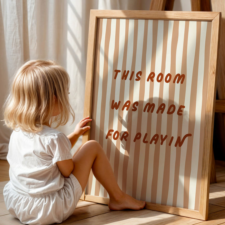 a little girl sitting on the floor next to a sign